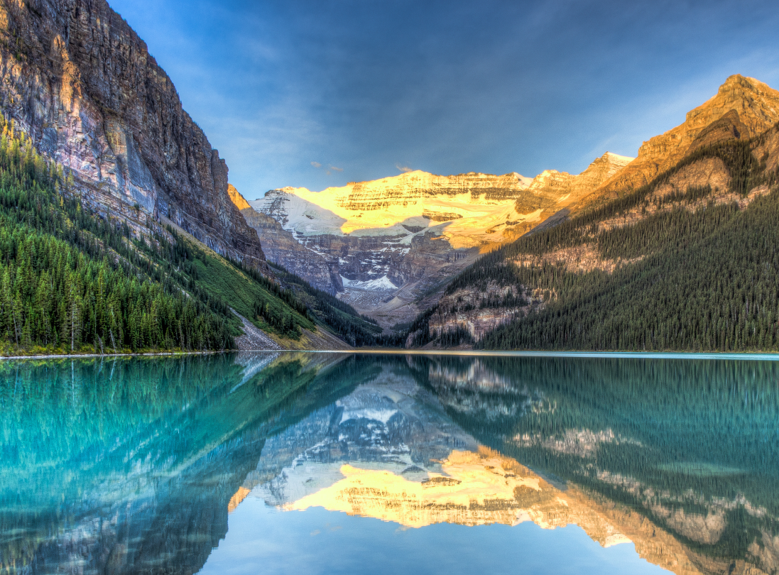Klarer Bergsee mit Spiegelung von Bergen im Sonnenlicht, Symbol für innere Klarheit, innere Ruhe und Stabilität.
