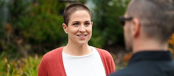 Rebekka Thommen bei einem Retreat im Gespräch mit einem Teilnehmer, in einer natürlichen und entspannten Umgebung.