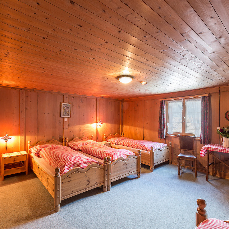 Schlafzimmer mit Holzausstattung und gemütlichen Betten, ideal für Erholung, Selbstfürsorge und Selbstliebe.